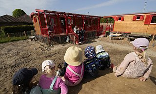 Der Lehmhügel im Garten ist im Moment einer der Lieblingsorte der Kinder, die im Foto nicht erkannt werden sollen. Auf der Treppe stehen mit Leiterin Sylvie Scholz, Laura Beckmann und Annika Becker drei Erzieherinnen aus dem Viererteam. Es fehlt Melanie Block.? - Gerald Dunkel