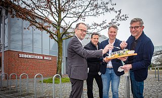 Martin Knabenreich (v.l., Bielefeld Marketing), Sportamtsleiter Klaus Böhm, Gastronom Christian Nahmmacher und Stadthallen-Manager Stephan Kipp genießen eine Kostprobe. Foto: Mike-Dennis Müller - Mike-Dennis Müller / www.mdm.photo