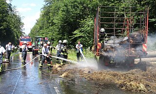 Die Feuerwehrleute löschen die brennenden Ballen. - Burkhard Battran