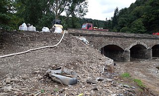 Mit einer Schlauchleitung über die teilzerstörte Brücke wird das Abwasser zur Kläranlage gefördert. - THW