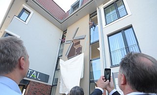 Im September 2018 wurde das Ärztehaus in Rahden eingeweiht. Zum Abschluss des offiziellen Teils wurde das Logo enthüllt. Das zeigt die einst in diesem Bereich stehende Mühle, die dem Neubau den Namen gab. Den besonderen Moment hielten auch Gäste per Smartphone fest. - Joern Spreen-Ledebur
