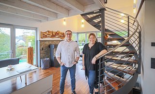 Stefanie und Michael Groß wissen ihr neues, großzügiges Zuhause sehr zu schätzen. Hingucker ist eine geschwungene Stahltreppe mit zum Bodenbelag passenden Holzstufen, die auf die Galerie und in die obere Etage mit Bibliothek, Schlaf- und Badezimmer führt. - Sarah Jonek