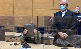 Der Angeklagte (verdeckt mit einem Aktenordner) wird hier kurz vor dem Urteilsspruch in den großen Saal 1 des Landgerichtes Bielefeld geführt. - Archivfoto/ Wolfgang Wotke