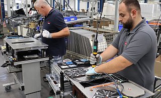 Viktor Sazanskiy (v. l.) und Emre Koyuncu fertigen Induktionskochfelder mit integrierter Abzugshaube im Bünder Imperial-Werk von Miele an. - Shannon-Lee Bendig