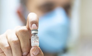 Ein Apotheker hält eine Ampulle mit 6 Dosen des neuen an die Omikron-Sublinie XBB.1.5 angepassten Corona-Impfstoffs in einer Apotheke. - Christophe Gateau