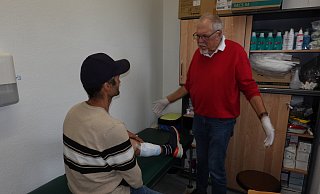 Der erste Patient in der ersten Sprechstunde für Obdachlose im B2 wird von Arzt Theo Schaten behandelt. Er hat eine Wunde am Bein. - Sento/Liborius Zacharias