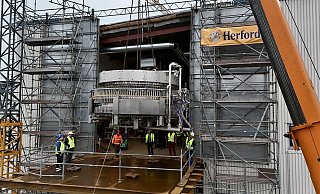 Maßarbeit: Durch das große Loch im Gebäude wird die Etikettiermaschine an ihren Bestimmungsort gebracht. - Herforder Brauerei