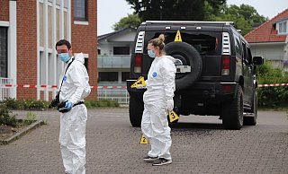 Zwei Spezialisten der Spurensicherung vor dem beschossenen Geländewagen. Zwei Einschüsse am Heck sind erkennbar, doch es soll mehrere Treffer geben. - Charlotte Mahncke
