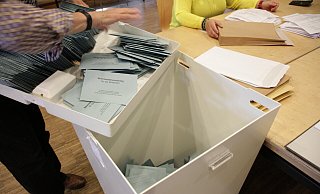 Die blauen Stimmzettelumschläge landen in der Wahlurne. - Dieter Scholz