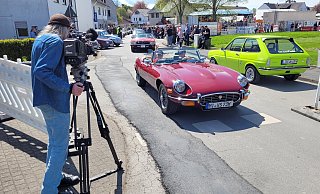 Zahlreiche Auto-Fans sind mit ihren Schätzen nach Stift Quernheim gekommen. Hier winken zwei Oldtimer-Freunde dem Filmemacher Norbert Kaase in die Kamera. - Florian Weyand