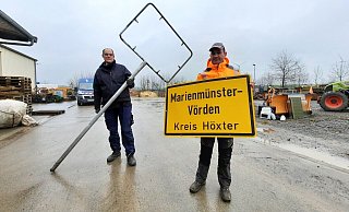 Josef Welling und Thorsten Müller zeigen auf dem städtischen Bauhof das Schild, das in der Tannenschonung gefunden worden ist. - Madita Schellenberg