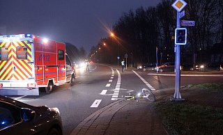 Das Fahrrad des 40-Jährigen blieb am Rand der Fahrbahn auf dem Boden liegen. Ein Rettungswagen steht auf der Kreuzung. - Polizei Minden-Lübbecke