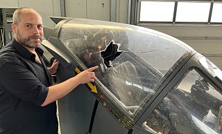 Marc Tecklenborg zeigt auf das große Loch, das die Einbrecher mit viel Zerstörungswut in der Cockpit-Scheibe des Harriers hinterlassen haben. Der Ersatz kann sehr teuer werden. - Matthias Gans