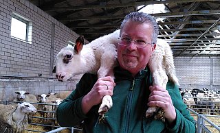 Michael Stücke zeigt, wie Schafe richtig getragen werden. Das Lamm auf seinen Schultern ist ein Flaschenkind und sehr zutraulich. - Judith Gladow