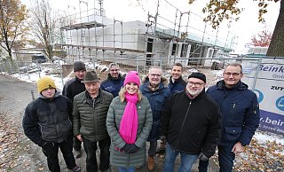 Zufriedene Gesichter in eisiger Kälte. Kita-Leiterin Nicole Zörner mit Superintendent Olaf Reinmuth (rechts dahinter) sowie den Vertretern des Architekturbüros Bäunker und Cawalla und der Zimmerei Gerhard Kienker (links). Der Rohbau dahinter soll in den kommenden acht Monaten bezugsfertig werden. - Gerald Dunkel