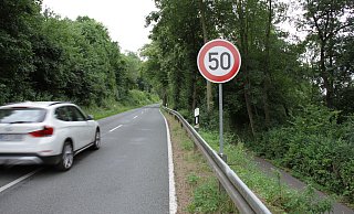 Ein mobil aufgestelltes Tempo-50-Schild weist am Fahrbandrand auf die Geschwindigkeitsreduzierung hin. Auf der schmalen und kurvigen Landesstraße leicht zu übersehen. Foto: Dieter Scholz - Dieter Scholz