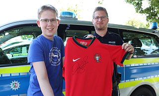 Marlon Westerbarkei (13) freut sich total, dass Polizeihauptkommissar Dennis Heitmann sein verloren geglaubtes Trikot gefunden hat. - Celina Allard
