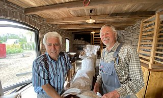 Wilhelm Nolting (l.) und Horst Brönstrup haben insgesamt 100 Kilogramm Getreide in der motorbetriebenen Hofmühle gemahlen. - Nicole Sielermann