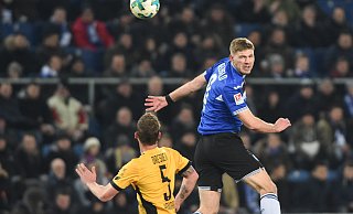 Fabian Klos (r., hier beim Kopfballduell gegen Dresdens Manuel Konrad im Februar 2018) ist bis auf zwei Unterbrechungen seit der Saison 2014/2015 Kapitän von Arminia Bielefeld. - Christian Weische