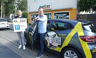 Auffällig gekennzeichnet durch den gelben Aufkleber Classic Car Sharing steht der Renault Clio vor dem Quartiersbüro an der Isenstedter Straße. Das Foto zeigt (l.) Vertriebsaußendienstmitarbeiter Marvin Griebe und in der Wagentür Mobilitätsmanager Nils Krenz. - Karsten Schulz
