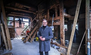 Thomas Lampe steht auf der Deele des alten Kötterhauses. Altes Fachwerk wurde freigelegt - hier soll ein Wohn-/Essbereich mit offener Küche entstehen. - Sarah Jonek