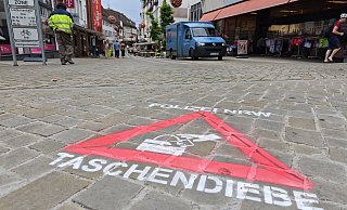 Mit Sprühkreide macht die Polizei in Höxter präventiv auf das Thema Taschendiebstahl aufmerksam. - Svenja Ludwig
