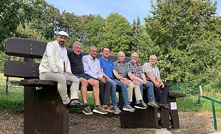 Da wirken Männer plötzlich wie Zwerge: Über die neue XXL-Sitzbank freuen sich (von links) Sascha Gödecke (Westfalen Weser), Manfred Zacharias, Franz Kudak, Gereon Potthast, Helmut Rohlfs, Bernhard Böddeker, Antonius Koch, Vorsitzender des Heimat und Kulturvereins Dahl. - Heimat- und Kulturverein Dahl