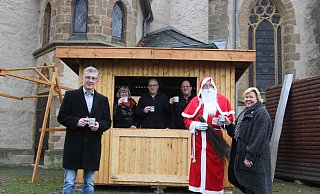 Bürgermeister Bernd Dumcke (v. l.), Anne Beckmann, Wolfgang Haase und Andreas Schmidt vom Aufbauteam, der Nikolaus und Regina Schlüter-Ruff freuen sich auf den Weihnachtsmarkt an der Martinskirche, wo bereits die ersten Hütten stehen. - Britta Bohnenkamp-Schmidt