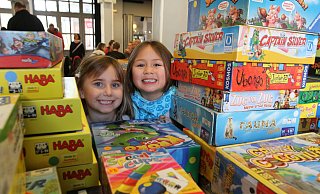 Auch bei der Spieleausstellung 2018- also vor Corona- gab es eine große Auswahl. Lilly (l.) und Hallimah hatten bei den Bergen von Kinderspielen die Qual der Wahl. Letztendlich wählten sie Funkelschatz. - Nicole Sielermann