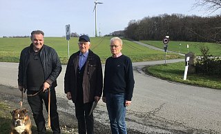 Matthias Moning, Claus Marzoll und Günter Stork stehen an der Abzweigung, bis zu der die Alte Heerstraße auch für Nichtanlieger frei befahrbar sein soll. Sie kündigen weitere Proteste gegen die jetzt beschlossene Regelung an. Hund Henry interessiert sich hingegen vor allem für Leckerlis. - Corina Lass