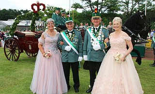 Das Hövelhofer Königspaar Matthias und Annette Vonderheide (r.) hat gemeinsam mit dem Zeremonienmeisterpaar Andreas und Ingeborg Joachim große Freude an der Parade im Schatten des Schützen- und Bürgerhauses. - Schützen Hövelhof