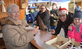 Die Holzarbeiten von Jürgen Natermann gingen am AWO-Stand weg wie warme Semmeln. Hier verkauft Waldtraud Meinecke kleine Elefanten an Tessa und ihre Mama. - Sibylle Kemna