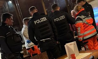 Polizeibeamte und Notfallsanitäter kümmern sich im Lokal um den verletzten Mann. Die Täter sind bereits geflüchtet. - privat