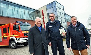 Bielefelds Oberbürgermeister Pit Clausen (l.) und Herfords Stadtoberhaupt Tim Kähler (r.) haben mit Carsten Kroll die Feuerwehr in ihre Mitte genommen. Sie stehen vor der Wache Nord an der Herforder Straße. - Barbara Franke