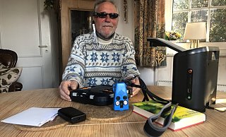Vor Gerhard Steffen liegen verschiedenen technische Hilfsmittel, die ihm das Leben erleichtern. Ganz rechts ist das Vorlesegerät zu sehen, das Texte erkennt, die man unter die Kamera legt. - Sven Kienscherf