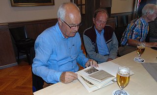Fachsimpeleien: Werner Aufderheide (l.) und Rainer Gehrke blättern eine der Ordner durch, die Rolf Siekmann mitgebracht hatte. Darin zu finden waren alte Fotos und Presseberichte, die schon 50 Jahre auf dem Buckel haben. - Dirk Kröger