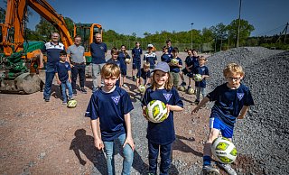 Halbzeit auf der Baustelle: Elias (7), Sophia (8), Elias (7, v.l.) und auch die anderen Mitglieder vom TuS Hoberge freuen sich, dass die alte Asche weg ist und sie auf ihrem Platz bald auf Kunstrasen kicken können. - Sarah Jonek Fotografie