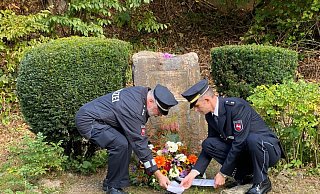 Gewerkschaftsvertreter Ralf Lorasch (links) und Oliver Busche, Leiter des Polizeikommissariats Holzminden, bei der Kranzniederlegung am Gedenkstein. - Polizei Holzminden