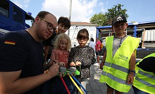 THW-Mann Daniel Hills hilft Johanna (4) und Alva (4) beim Steuern von aufblasbaren Hebekissen. Mika (6, rechts) und Finn (12, dahinter) sind danach dran. - Gerald Dunkel