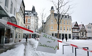 Mit Flatterband und einem Schild wurde bei Schnee am Neuen Markt in Herford vor Dachlawinen gewarnt. - Frank-Michael Kiel-Steinkamp,Frank-Michael Kiel-Steinkamp