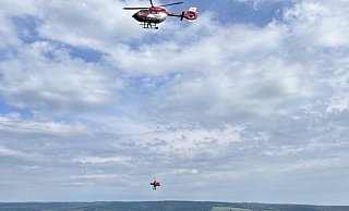 Der Rettungshubschrauber aus Dortmund hilft bei der Bergung des verletzten Gleitschirmfliegers. - Polizei Kreis Höxter