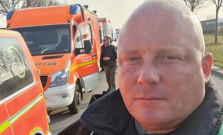 Maik Menke aus Paderborn steht vor einem Hilfskonvoi, der auf dem Weg in die Ukraine war und nun erneut startet. - NW