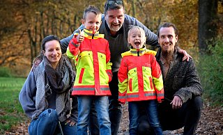 Thilo (6) und Amelie (4) sind begeistert von den bunten Jacken. Mutter Tatjana Diekmannshemke (33) (l.), Großvater Claas-Gerrit Niemöller (60) (hinten) und Onkel Gerrit Friedrich-Niemöller (31) (r.) wollen, dass Kinder auch in der dunklen Jahreszeit gesehen werden. - Andreas Frücht