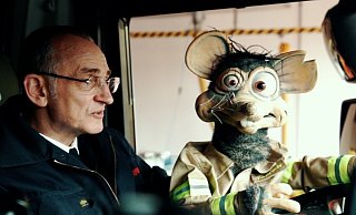 Robert Husemann von Paderborner Puppenspiele und "Rudi Ratte" zeigen den Kindern die Paderborner Feuerwache per Videopodcast. - Feuerwehr Paderborn