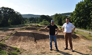 Dennis Fischer (Tiefbauamt, l.) und Michael Scholle (Erster Beigeordneter) stehen auf dem höher gelegenen Starthügel. - Stadt Bad Driburg