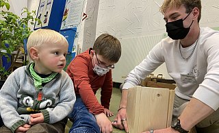Der achtjährige Jon aus Rinteln schraubt mit Jan Malte Seiffert von der Biologischen Station Ravensberg einen Nistkasten zusammen. Der zweijährige Fynn Luca schaut zu. - Wencke Meckenstock