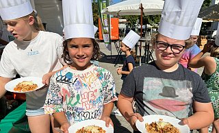 Emilio (l.) und Julius haben sich eine Portion Penne abgeholt und sind begeistert vom Geschmack. - Nicole Sielermann