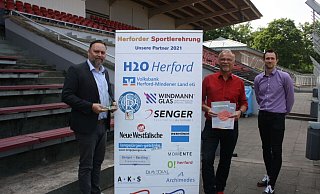 Vor der Tribüne des Ludwig-Jahn-Stadions: Herfords Sozialdezernent Patrick Puls (v. l.) sowie vom Stadtsportverband der Vorsitzende Jürgen Berger und Geschäftsführer Julian Schütz freuen sich, dass die Sportlerehrung für 2020 nun doch noch stattfinden kann. - Thomas Vogelsang