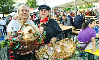 Heimatpflegerin Rosemary Flöthmann als Marktfrau Rosi (links) und Katrin Becker, die als Quirkendörperin auf dem Festplatz unterwegs ist, zeigen mit Ferkel und süßen Schweinöhrchen, worum es bei diesem jahrhundertealten Stadtfest geht. - Barbara Franke