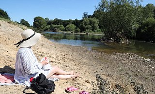 Picknick am Werrestrand: Diese junge Frau hat es sich am Ufer der Werre unterhalb des Sielwehres gemütlich gemacht und genießt den Blick auf den Fluss. - Jörg Stuke